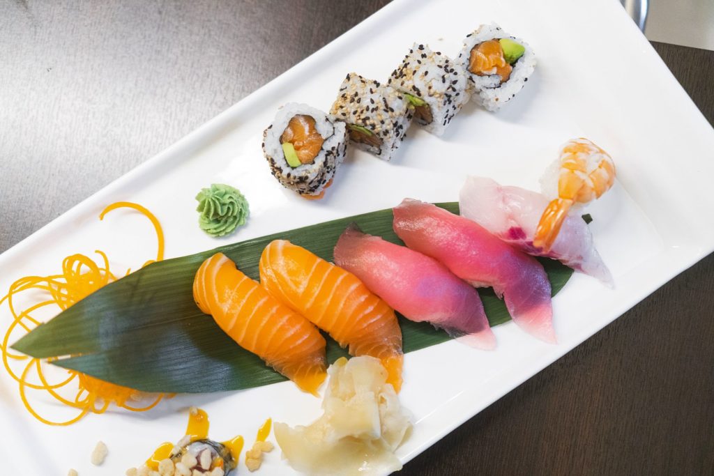 fooda_008 assortimento di sushi e nigiri con salmone, tonno e gambero serviti su piatto bianco elegante