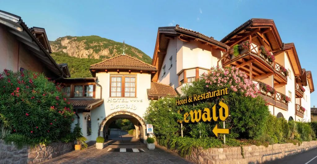ingresso dell’hotel e ristorante Lewald a Bolzano con insegna e fioriere