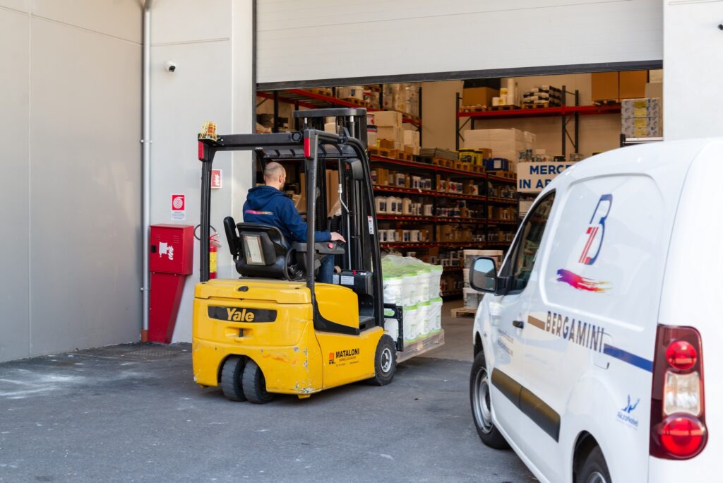 Operatore del Colorificio Bergamini a Bolzano che movimenta merce con un muletto davanti al magazzino aziendale
