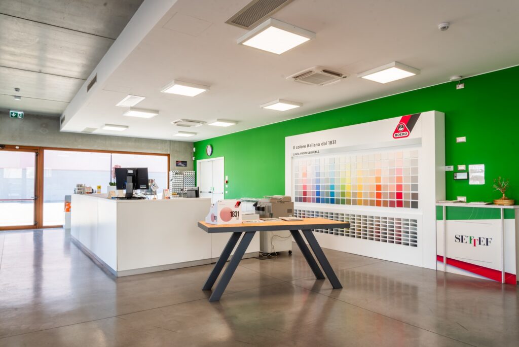 Ingresso e area reception del negozio Colorificio Bergamini a Bolzano, con esposizione di campioni colore e banco accoglienza.
