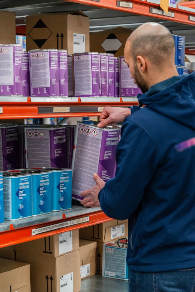 Tecnico del Colorificio Bergamini che preleva un contenitore di vernice dagli scaffali del magazzino